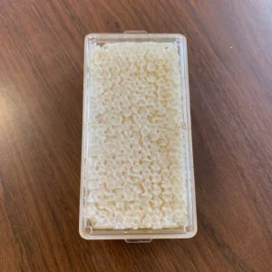 Raw honeycomb honey slice from Y.S. Eco Bee Farms USA on a wooden board