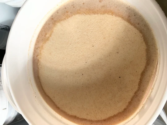 Liquid raw honey being poured, showcasing golden natural color